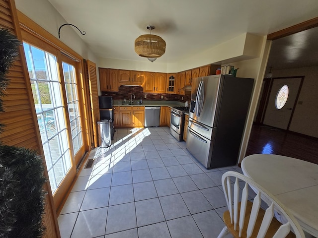 kitchen featuring light tile patterned floors, backsplash, stainless steel appliances, and sink