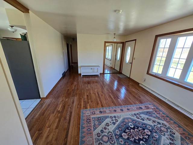 foyer with wood-type flooring and a baseboard heating unit