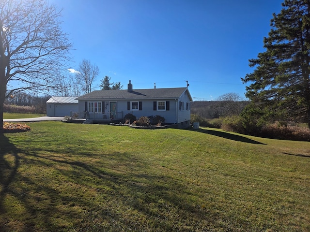 view of front of property with an outbuilding, a garage, a front lawn, and a wooden deck