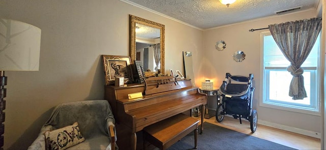 misc room featuring wood-type flooring, a textured ceiling, and ornamental molding