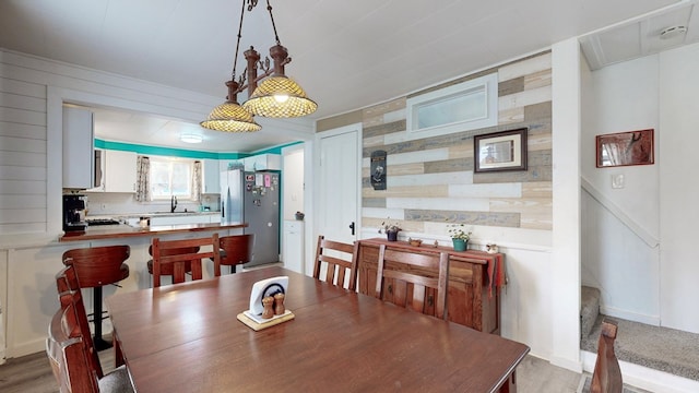 dining room featuring wood walls and sink