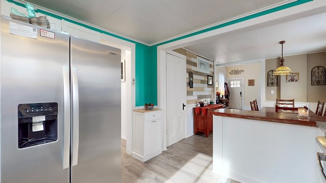 kitchen featuring white cabinetry, stainless steel fridge with ice dispenser, crown molding, pendant lighting, and light wood-type flooring