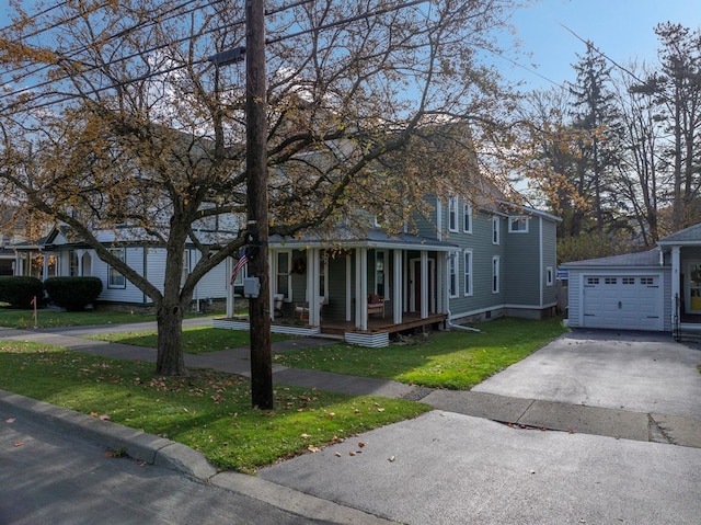 view of front of home featuring a front yard, a porch, an outbuilding, and a garage