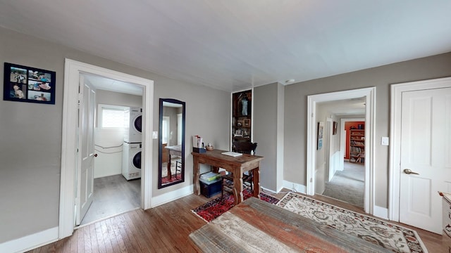 hall with hardwood / wood-style floors and stacked washer / drying machine