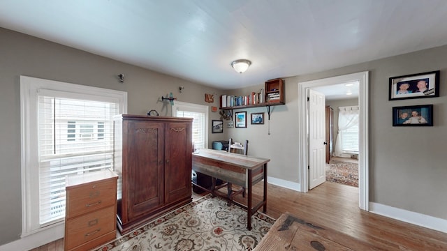 home office with a wealth of natural light and light hardwood / wood-style flooring