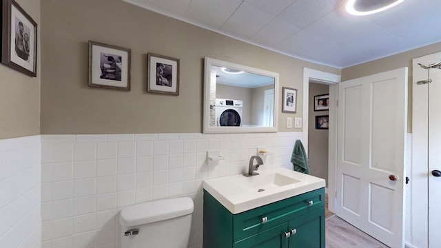 bathroom featuring vanity, crown molding, hardwood / wood-style floors, washer / clothes dryer, and toilet