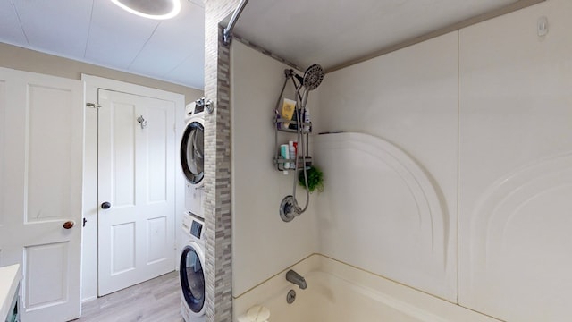 laundry area featuring light hardwood / wood-style flooring and stacked washer and clothes dryer