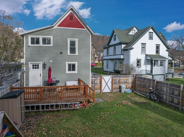 back of house with a lawn and a deck