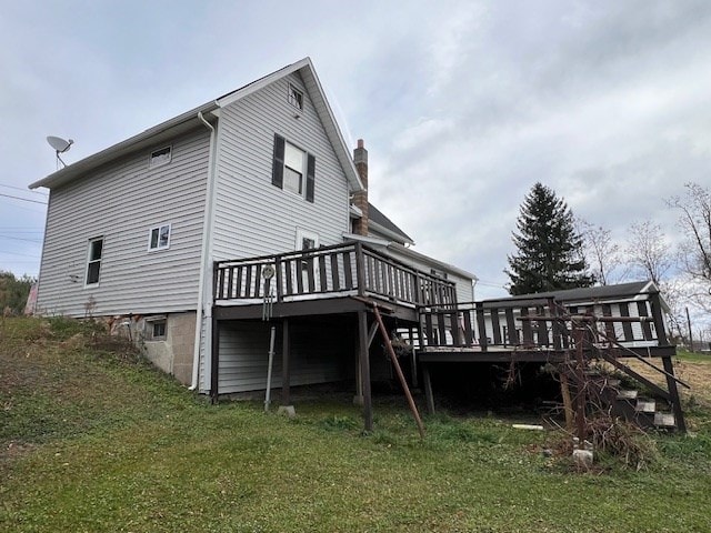 rear view of property featuring a lawn and a wooden deck