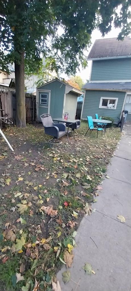 back of house featuring a storage shed