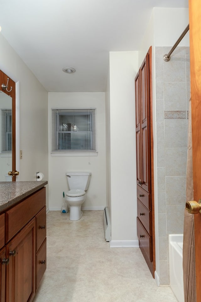 bathroom with toilet, vanity, and a baseboard heating unit