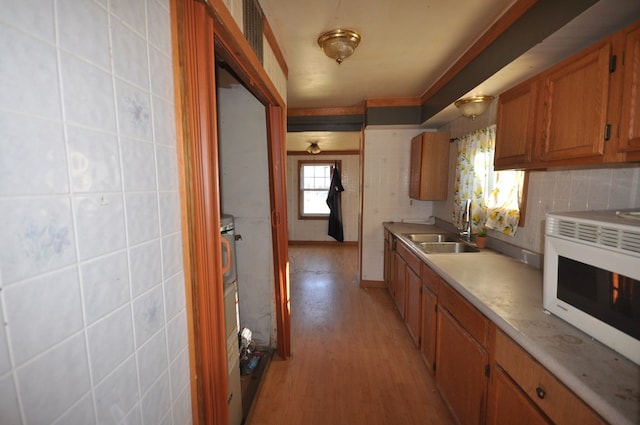 kitchen with backsplash, sink, and light wood-type flooring