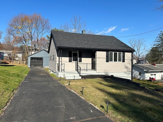 view of front of home featuring an outdoor structure, a front yard, and a garage