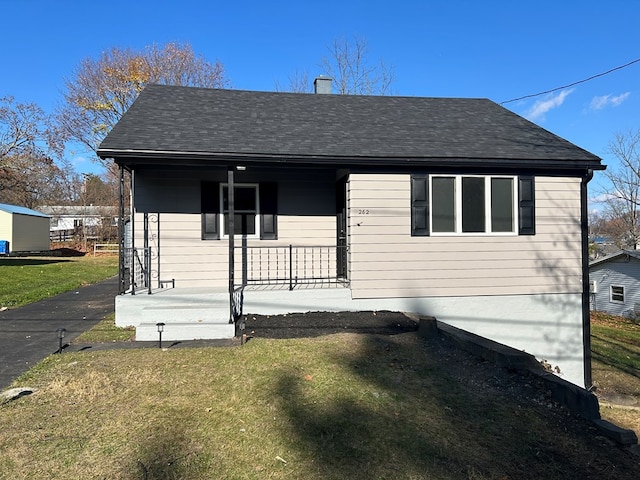 view of front of home with covered porch and a front lawn