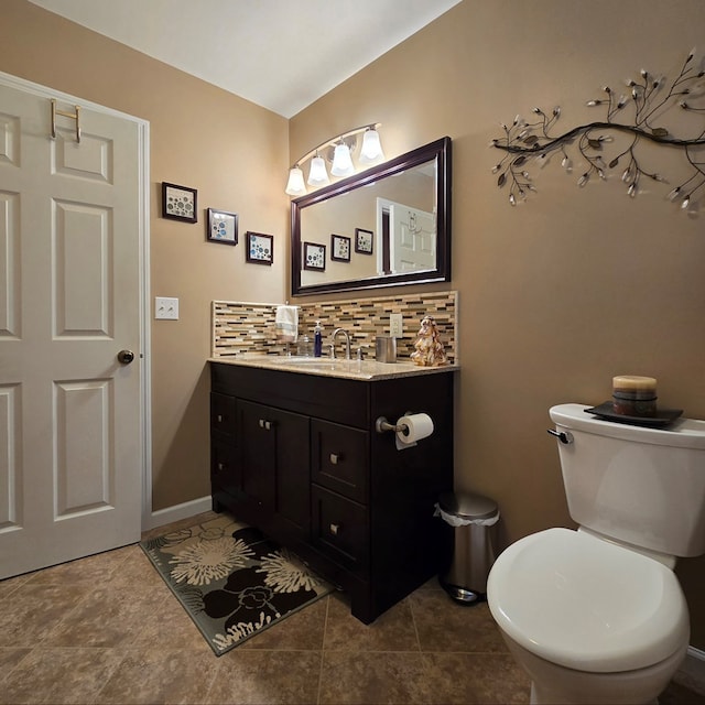 bathroom featuring vanity, backsplash, and toilet