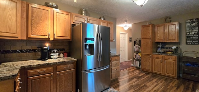 kitchen featuring stainless steel fridge, a textured ceiling, dark hardwood / wood-style floors, and tasteful backsplash