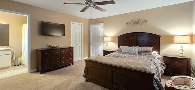 bedroom featuring ensuite bathroom, ceiling fan, and light colored carpet