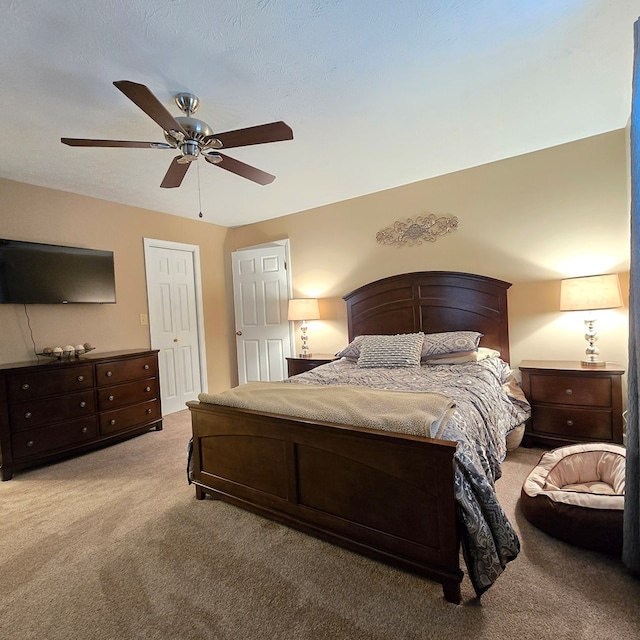 carpeted bedroom featuring ceiling fan and a textured ceiling