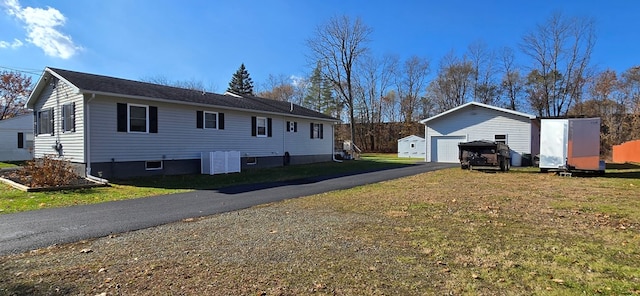 view of side of home with an outbuilding, a yard, and a garage