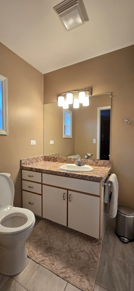 bathroom with tile patterned floors, vanity, and toilet