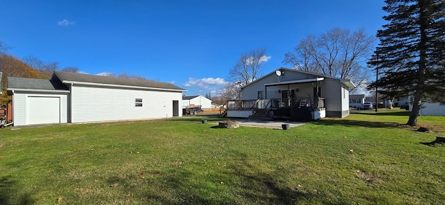 back of property featuring a yard, a fire pit, and a garage