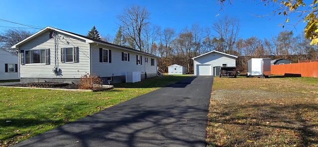 view of property exterior featuring a lawn, a garage, and an outbuilding