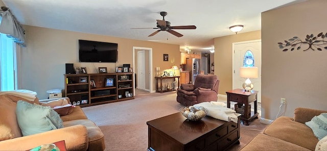 living room featuring a wealth of natural light, light carpet, and ceiling fan