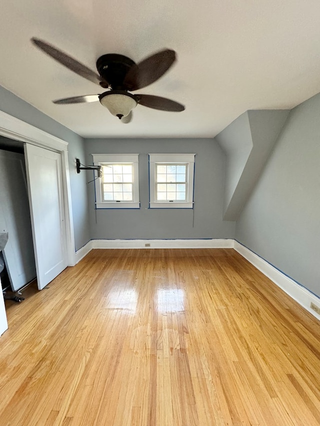 unfurnished bedroom with ceiling fan, a closet, and light wood-type flooring