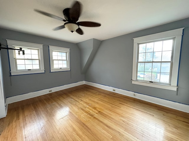 spare room featuring ceiling fan, a healthy amount of sunlight, and light hardwood / wood-style flooring