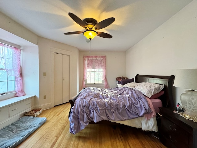 bedroom featuring ceiling fan, light hardwood / wood-style floors, and a closet