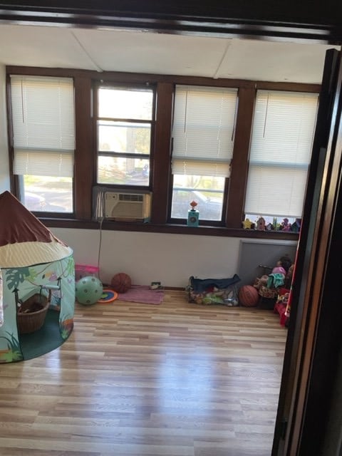 game room with cooling unit and light hardwood / wood-style flooring