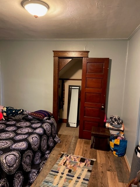 bedroom featuring light wood-type flooring and ornamental molding