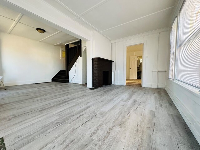 unfurnished living room featuring a fireplace and light hardwood / wood-style flooring