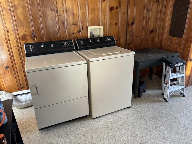 laundry room featuring washer and dryer and wood walls