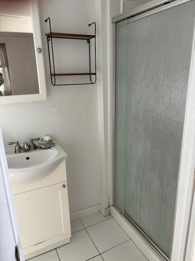 bathroom featuring vanity, tile patterned floors, and a shower with door