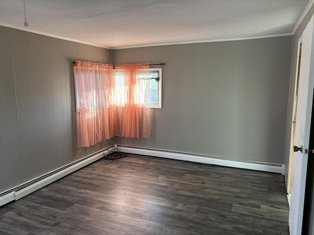 spare room with baseboard heating, crown molding, and dark hardwood / wood-style floors