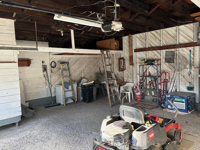 garage with a garage door opener and wooden walls