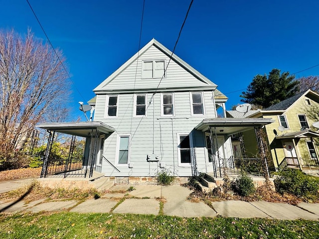 rear view of house featuring covered porch