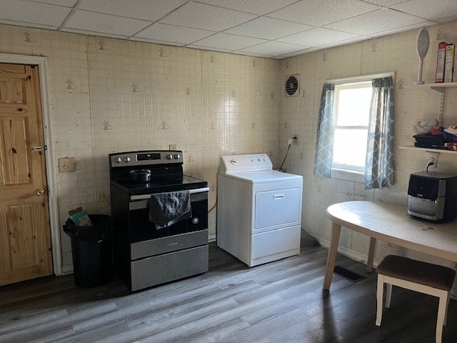 laundry room with wood-type flooring and washer / dryer