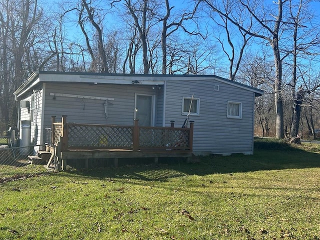 rear view of property featuring a yard and a wooden deck