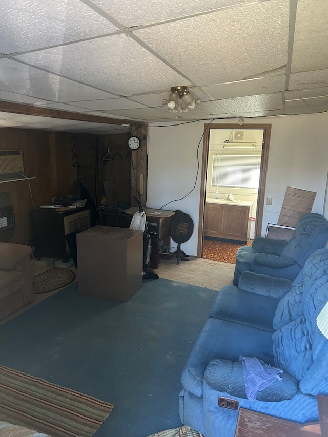 carpeted living room featuring a drop ceiling