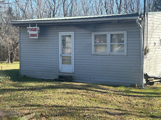 view of exterior entry featuring a yard