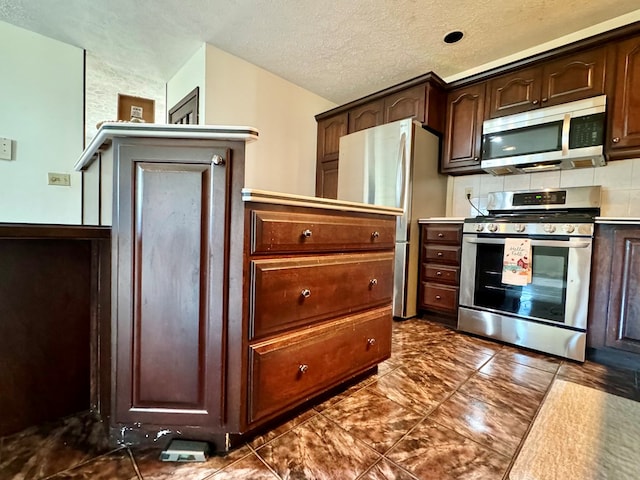 kitchen with dark brown cabinets, stainless steel appliances, and a textured ceiling