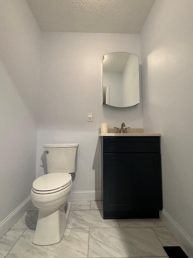 bathroom featuring vanity, toilet, and a textured ceiling