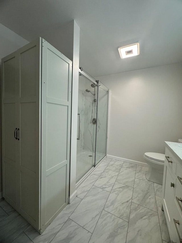 bathroom with vanity, toilet, and a shower with shower door