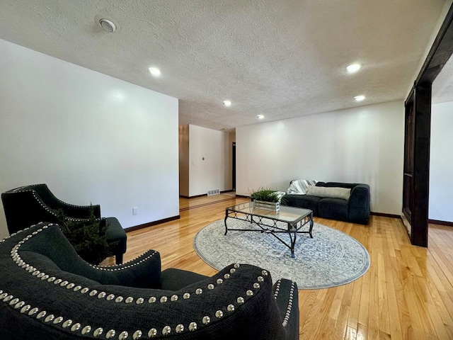 living room featuring hardwood / wood-style flooring and a textured ceiling