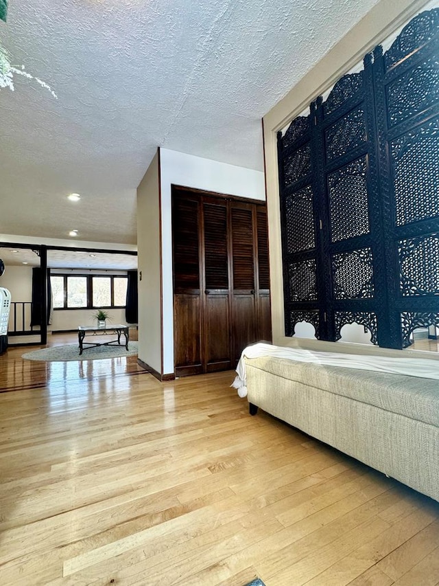 bedroom with a textured ceiling and light wood-type flooring