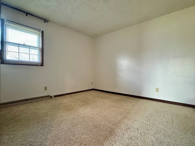 unfurnished room featuring a baseboard heating unit, a textured ceiling, and carpet