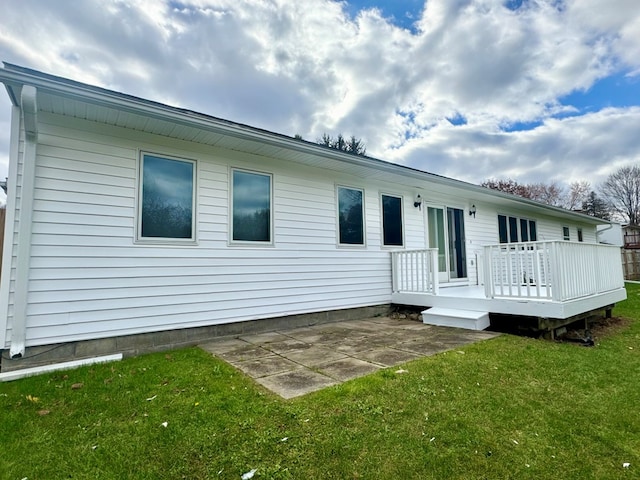 back of house with a wooden deck, a yard, and a patio area