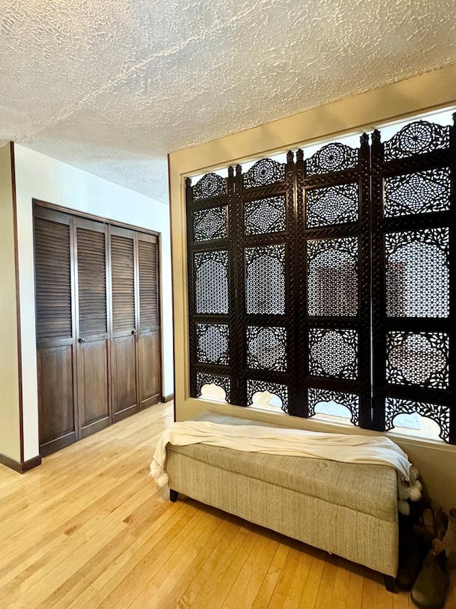 bedroom featuring hardwood / wood-style flooring and a textured ceiling